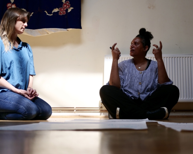 A choir member sat on the floor of the Unitarian Hall writing, coming up with lyrics for a co-written piece with the orchestra
