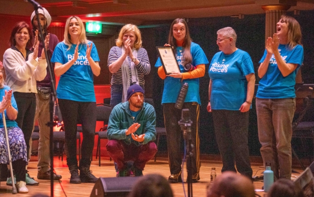 The choir smiling and clapping while being awarded the High Sheriff Award at the High Sheriff concert in 2024 at St George's