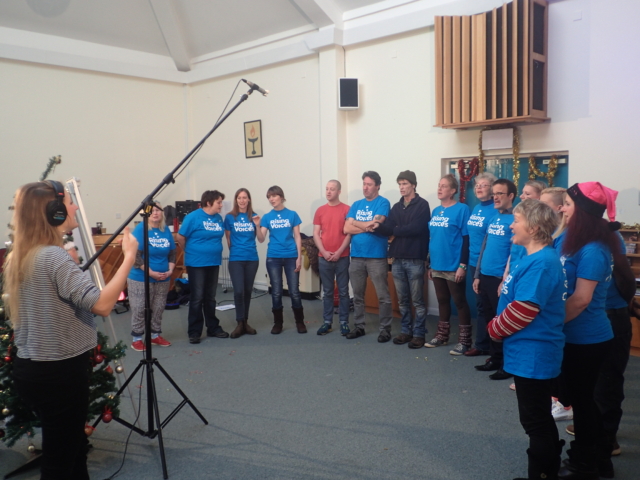 The choir standing in a semi-circle while being filmed by the BBC for Christmas 2016