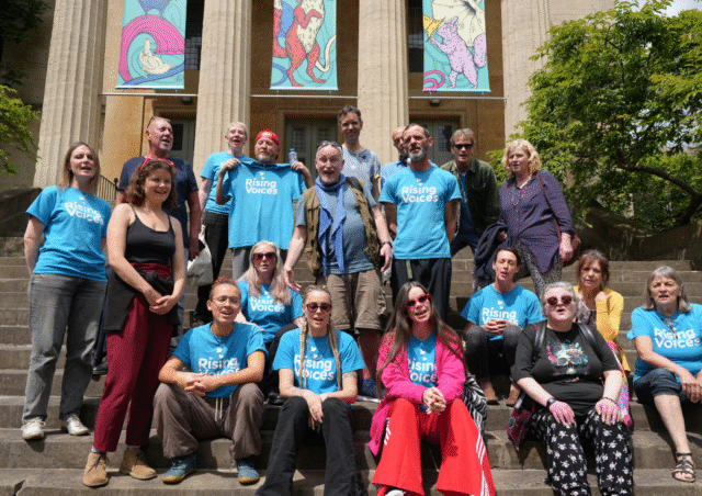 A group photo of Rising Voices standing on steps outside of St George's