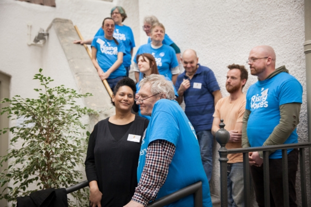 The choir standing in two rows going up some steps for a gig performance
