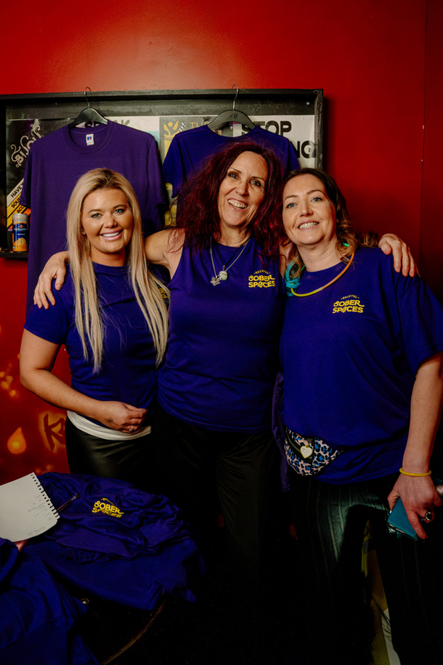 Three Bristol Sober Spaces volunteers stood together smiling for a photo at our sober rave at Basement 45