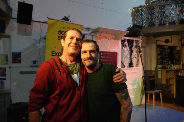 Two friends stood together smiling for a photo at our open mic at Zion Cafe in Bishopsworth