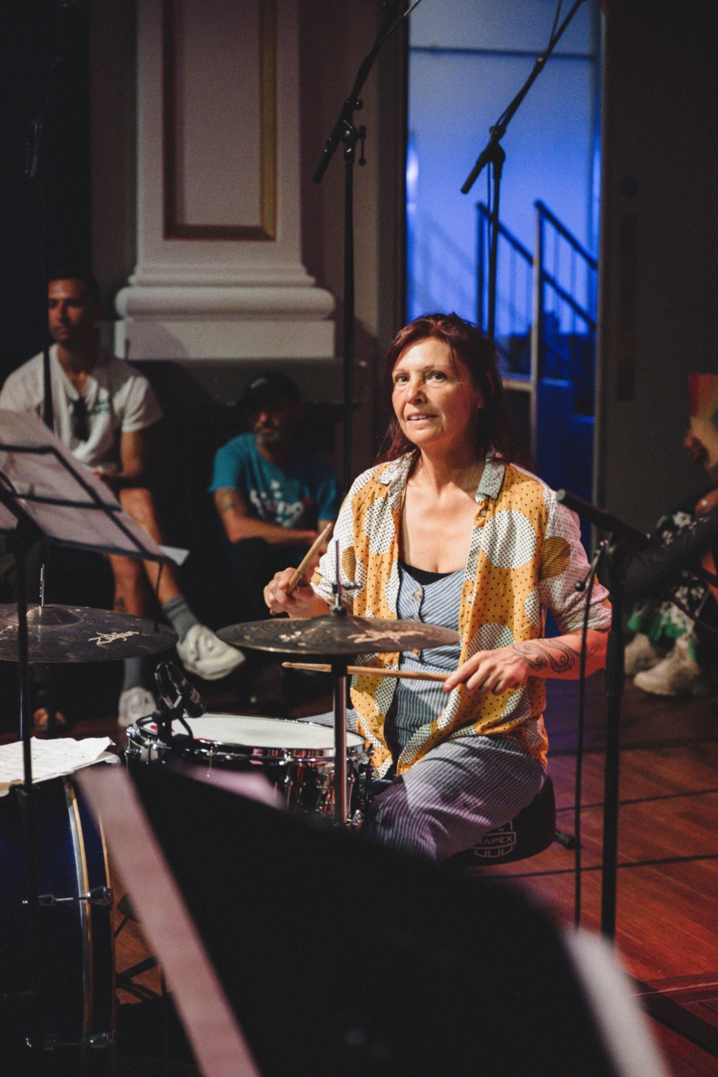 A group member playing drums are party of the Trinity music group at the Creative Communities Summer Showcase, 2025.