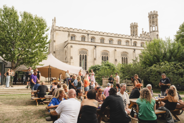 People sitting in the sunny garden at Trinity during our sober day rave