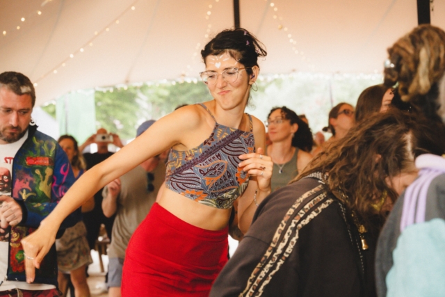 A crowd member dancing with her hands in the air at our sober day rave, Trinity August 2025.