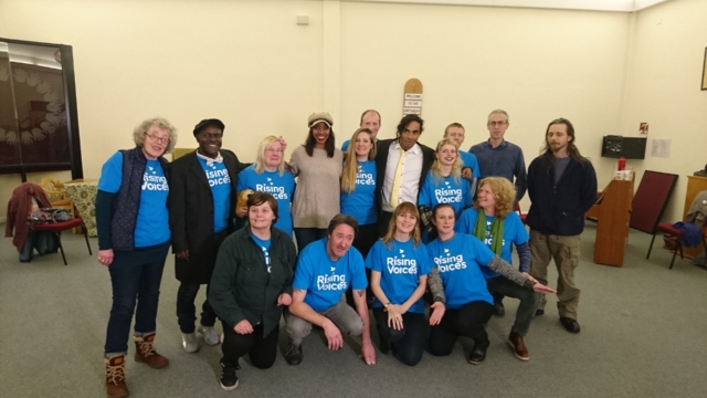 The choir huddled together smiling for the BBC filming of them for Songs of Praise