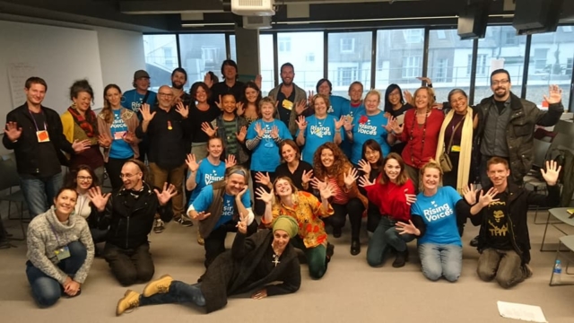 The choir huddled in a group smiling for a photo after a performance