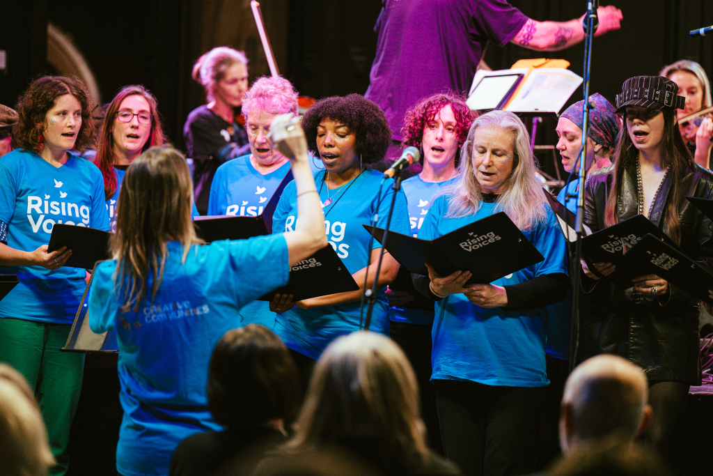 Rising Voices on stage singing at the winter show at Trinity